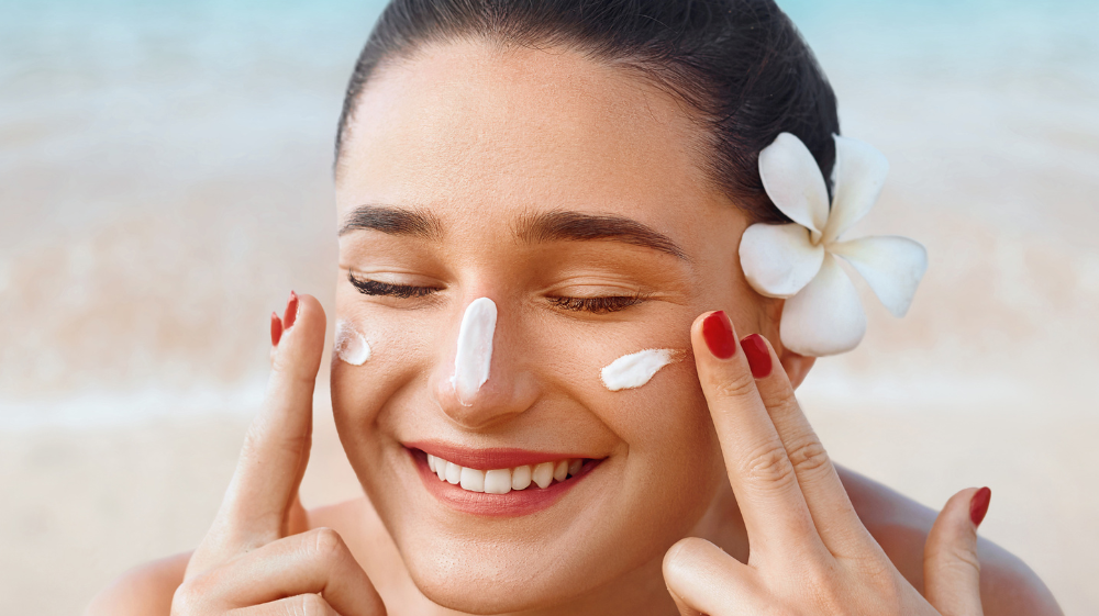 Applying sunsceen on the beach to someone with sensitive skin