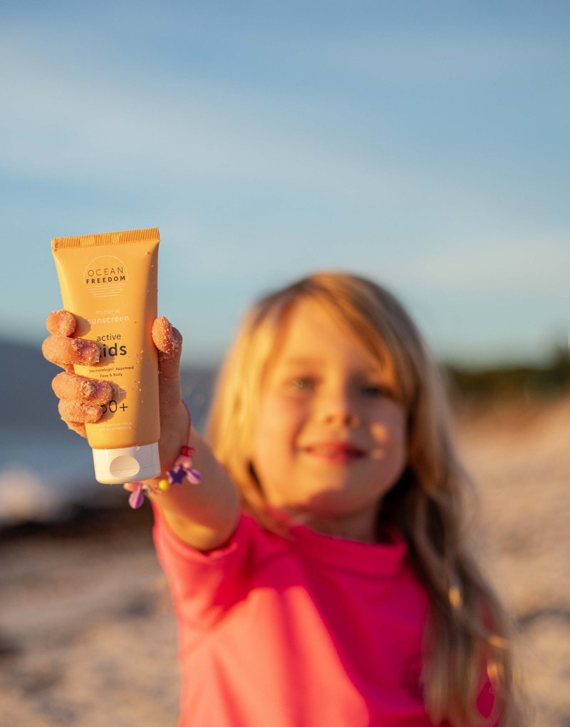 a Girl holding up Ocean Freedom SPF 50+ Kids Active Sunscreen